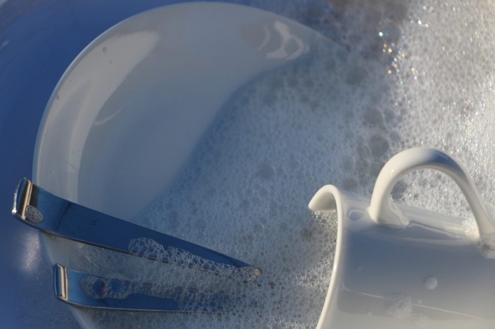 Plat avec eau savonneuse, assiettes et ustensiles