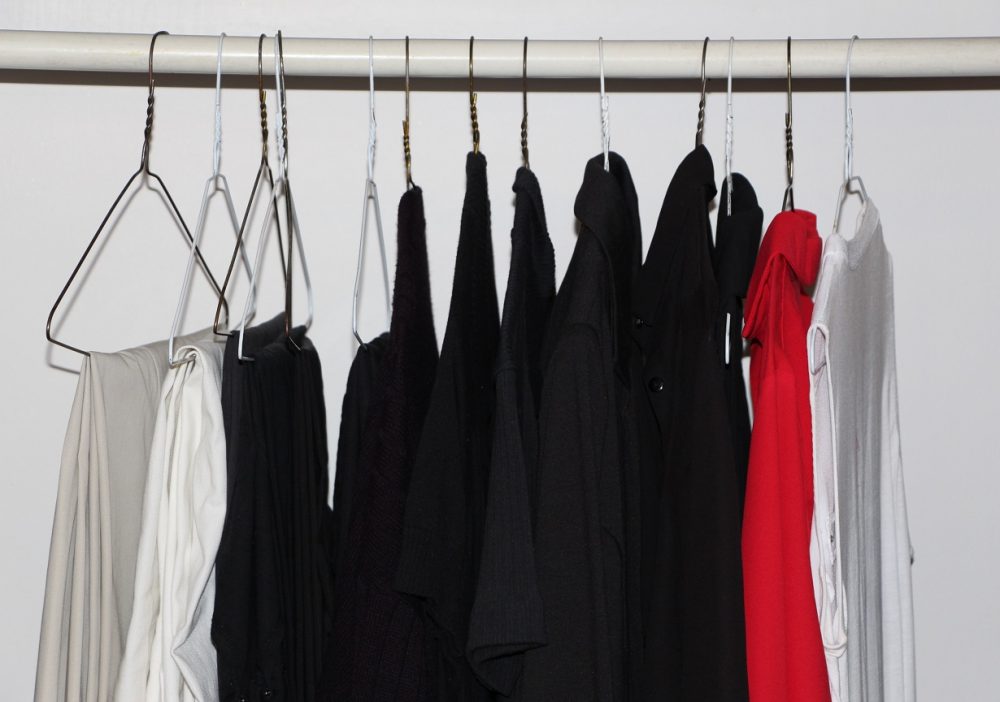 Pantalons, vestons et hauts sur cintres.